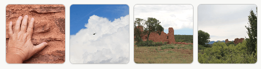 A close-up of a hand touching a textured red rock surface.